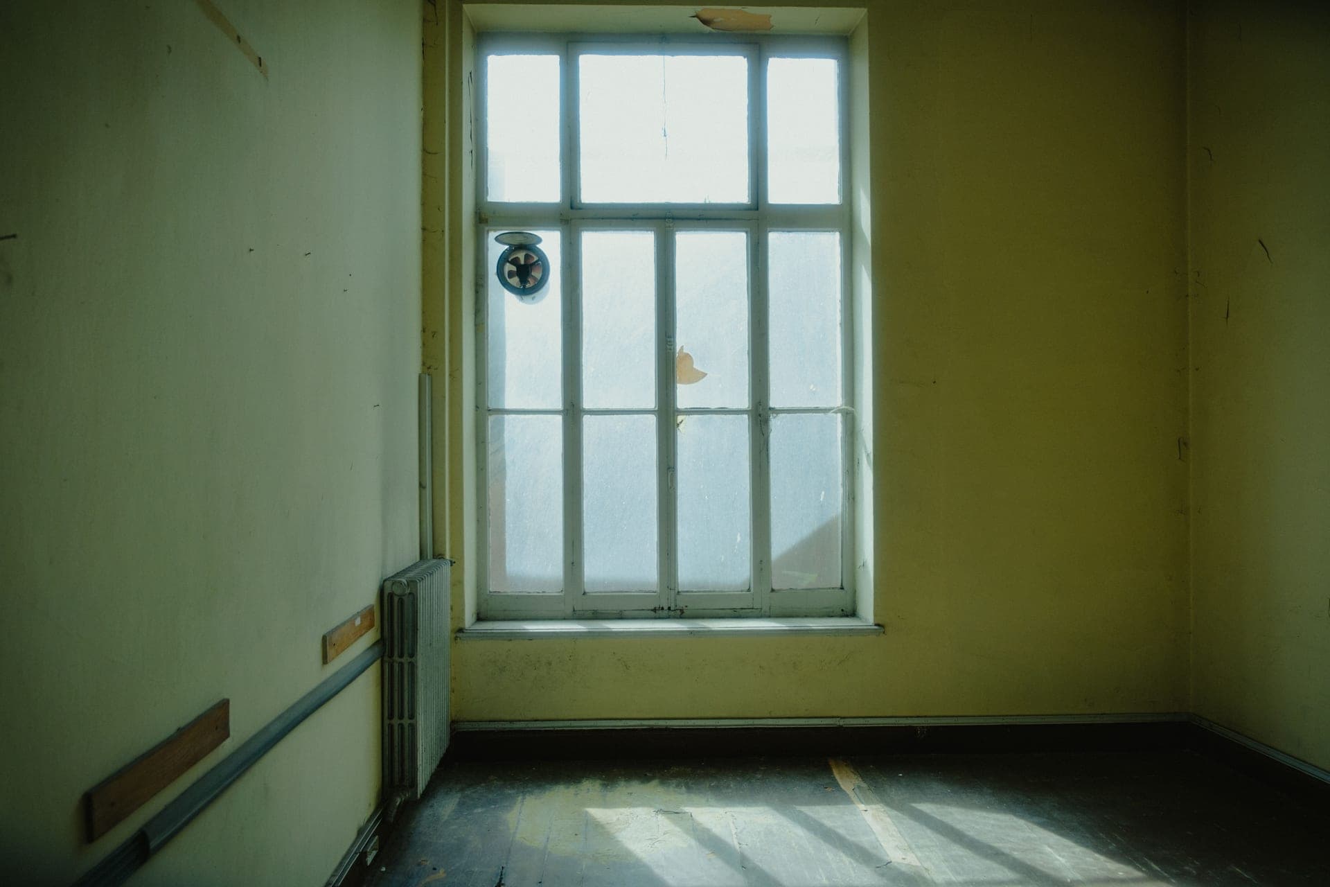 Sunlight streaming through a window into an empty room
