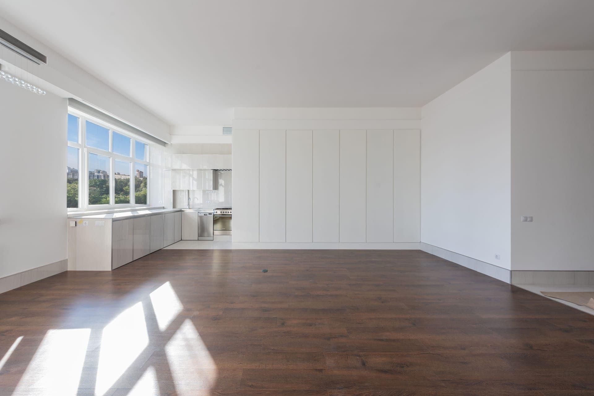 A sunlit apartment living area with wooden floors