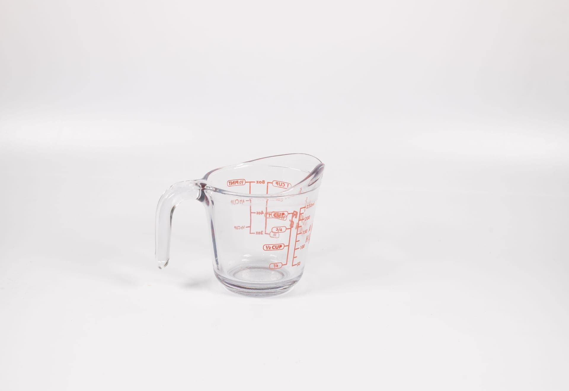A glass measuring jug of water on a kitchen counter