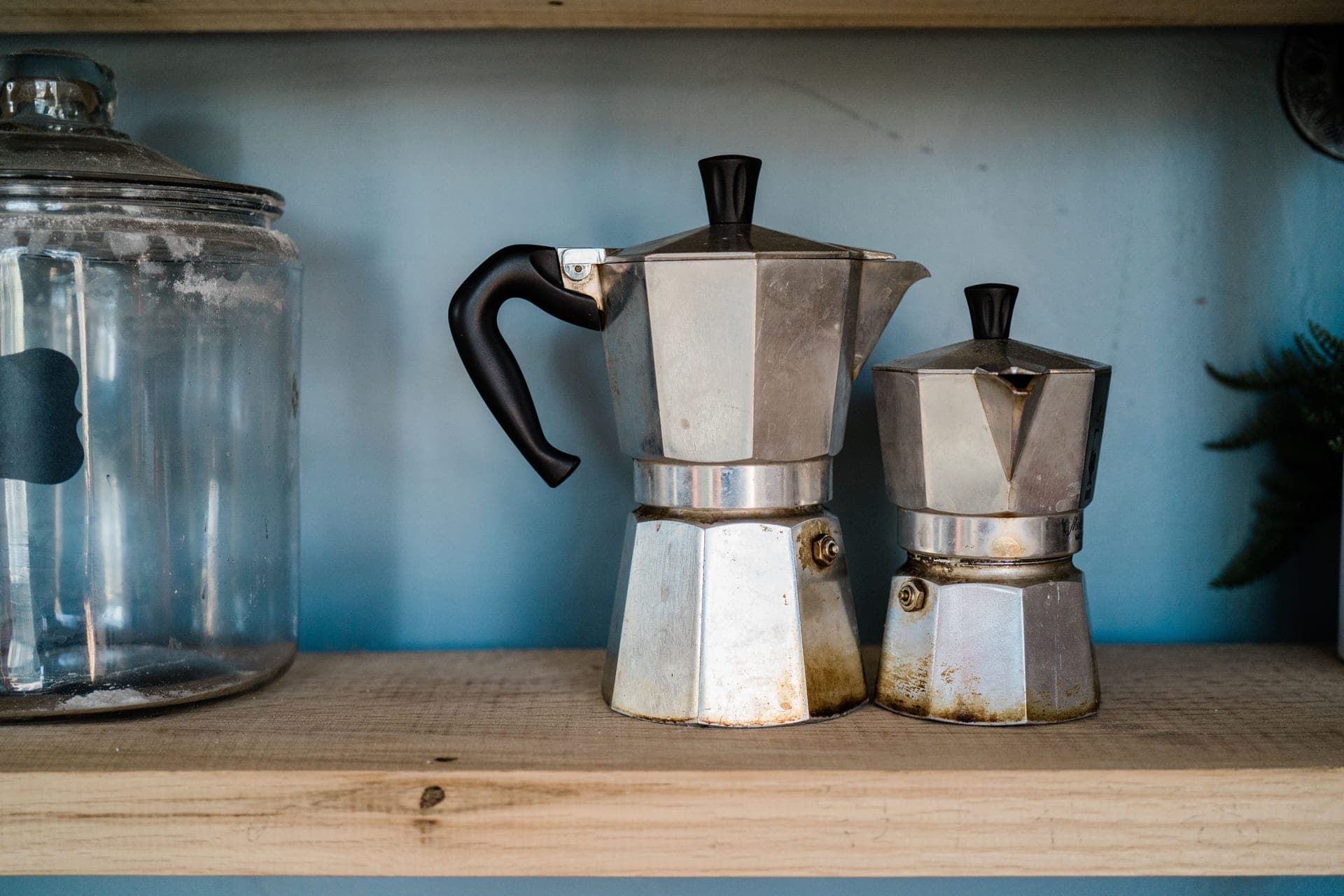 Two well-used metal kitchen appliances on a wooden surface