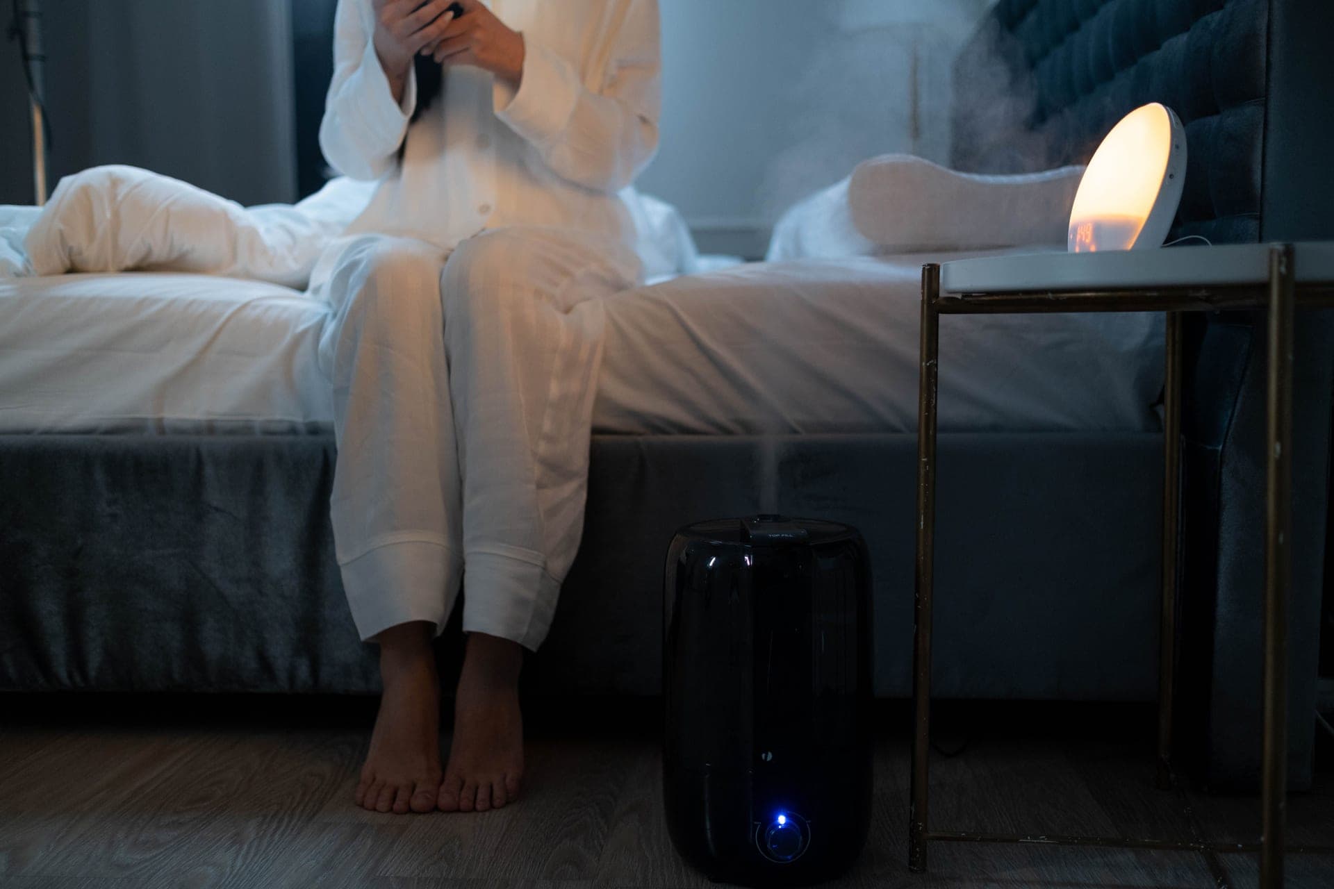 Humidifier mist lit softly in a dark bedroom