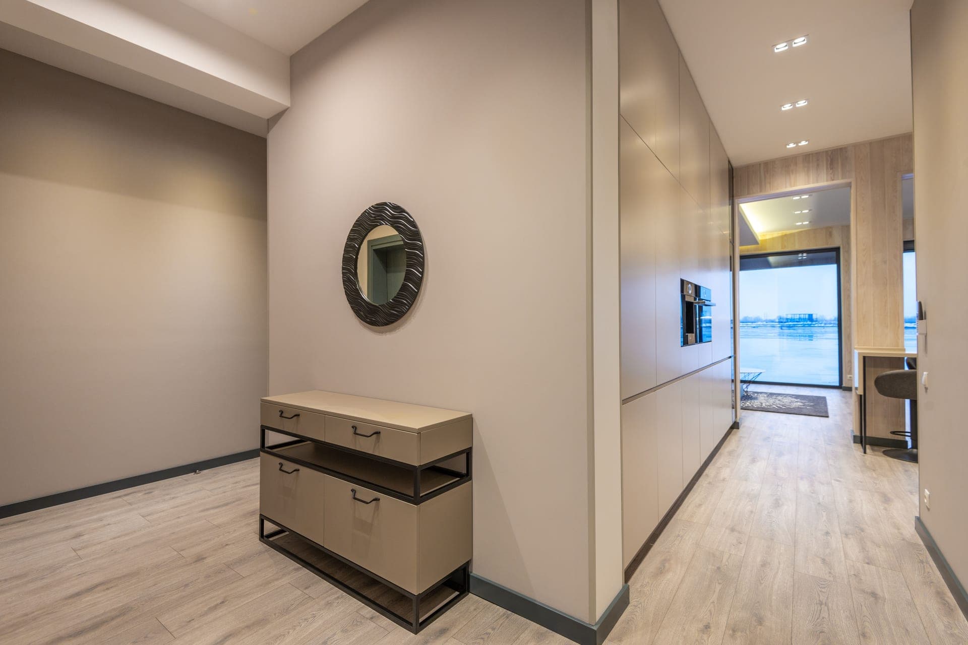 A low wooden cabinet against a wall in a bright hallway