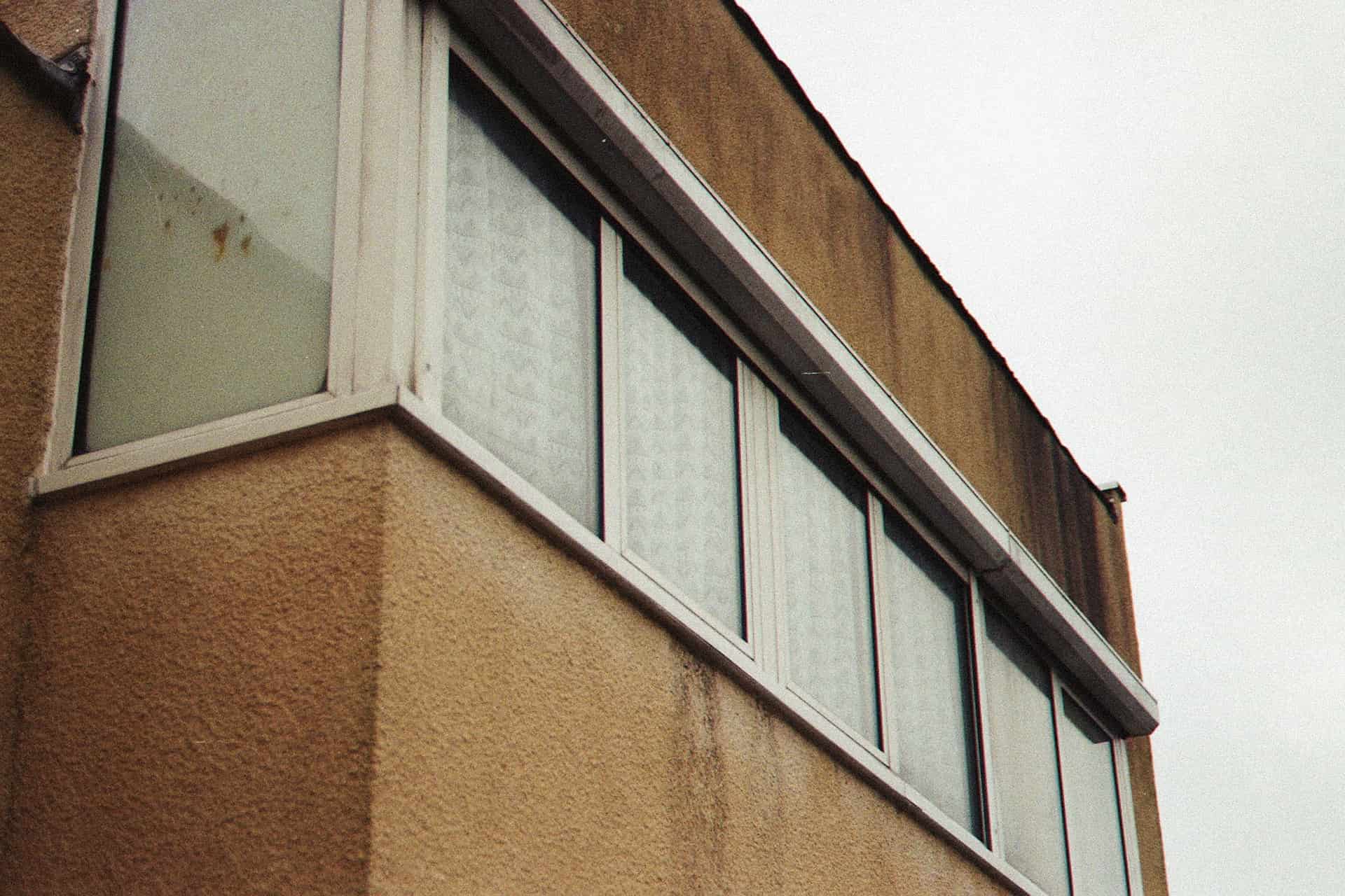 A damp window frame with dark staining in the corner