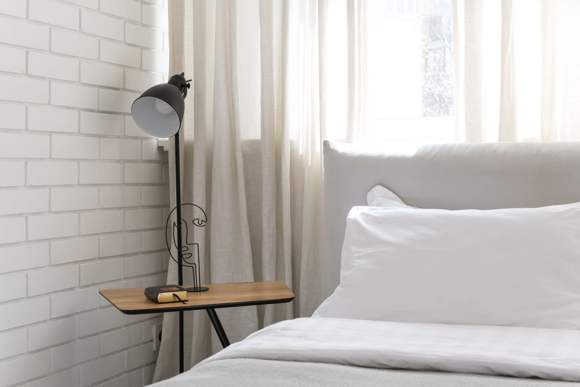 A minimal white appliance on a bedside table