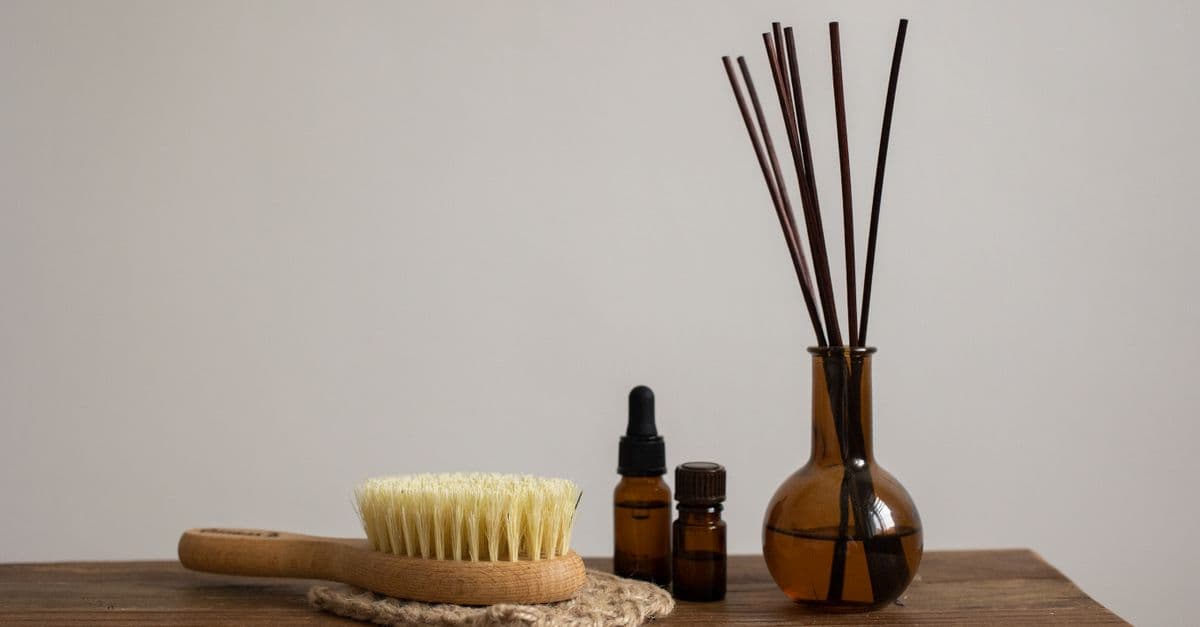 Small glass bottles and a brush arranged on a pale surface