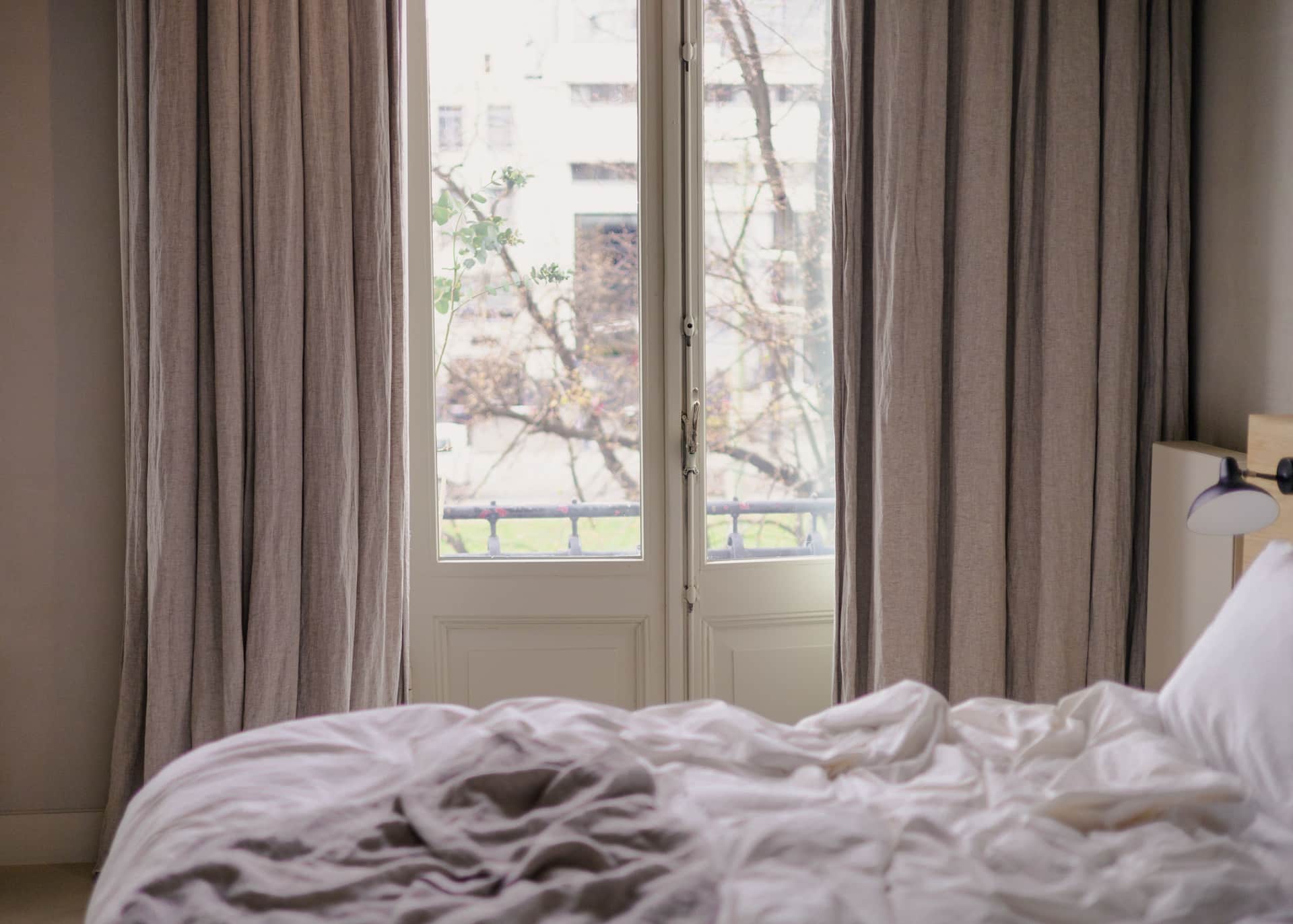 A still, dark bedroom with curtains drawn