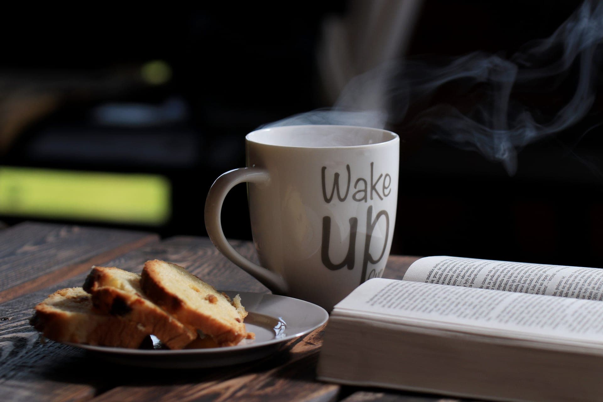 A steaming cup on a wooden table on a cold morning