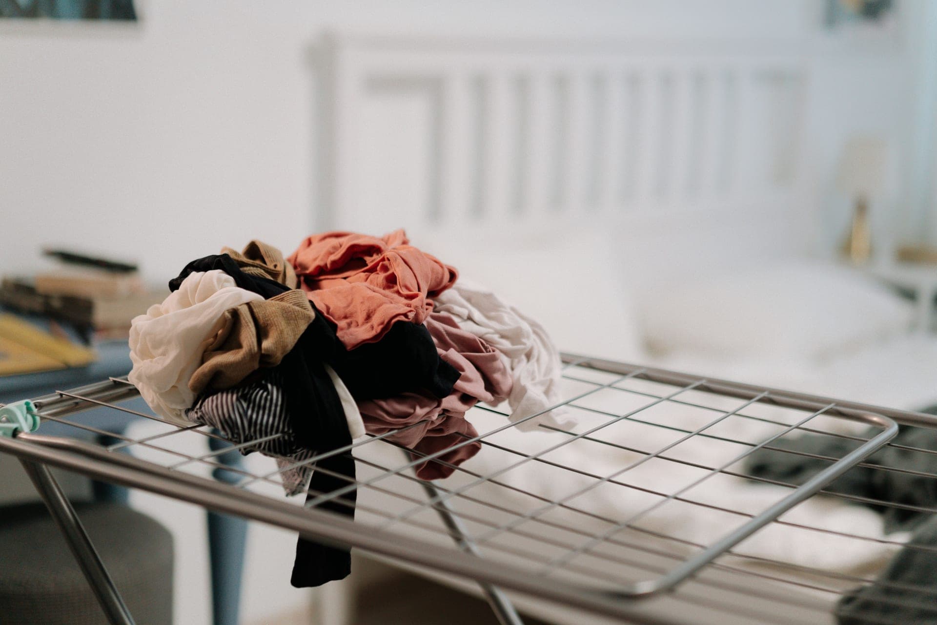Clothes drying on an indoor rack beside a window