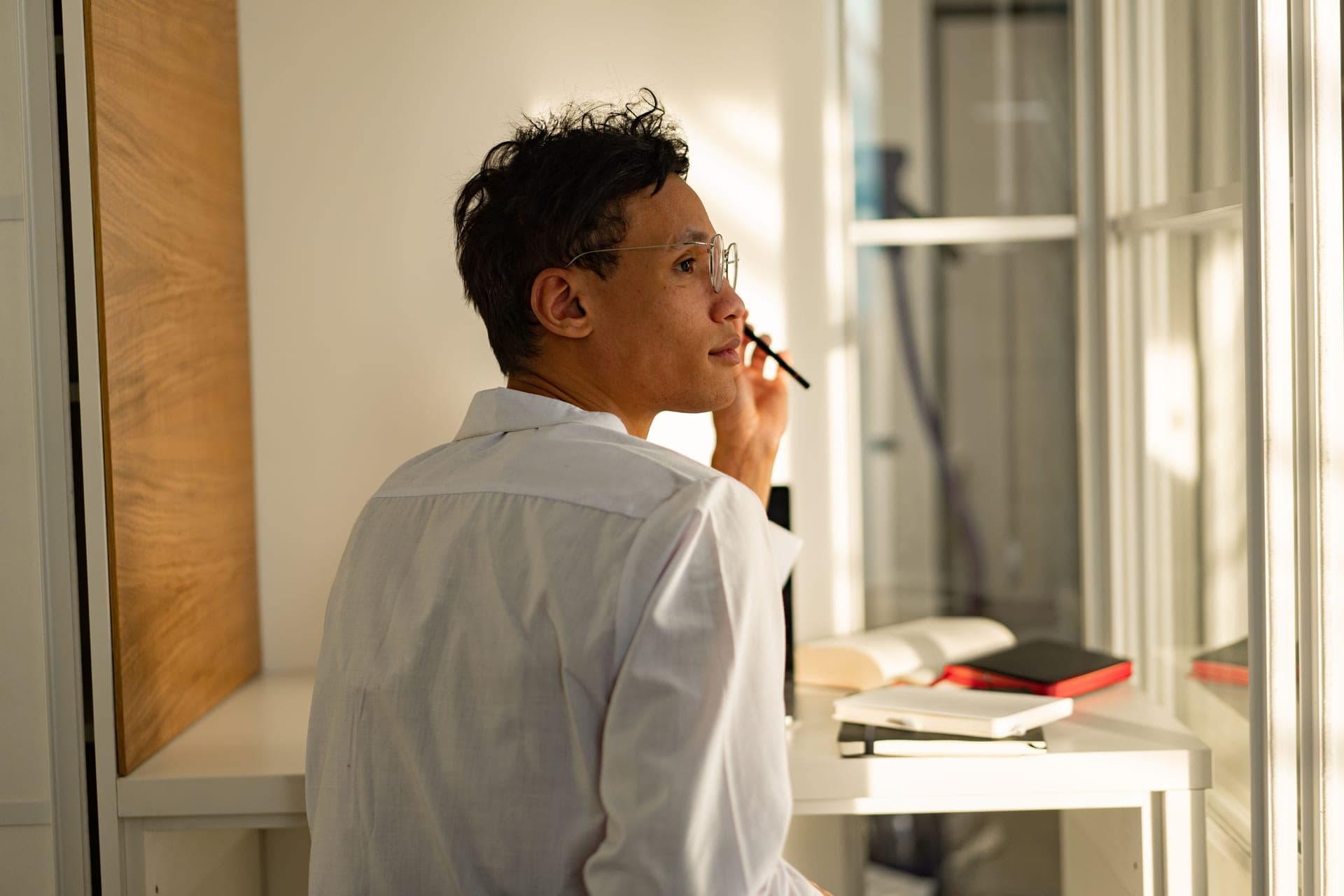 A person looking thoughtfully out of a window